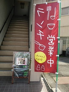 新TUMMY CAFE(タミーカフェ)の入口階段前に「ランチ営業中」のノボリ