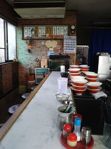 めんめん亭 国分店の左側厨房近くはラーメンどんぶりが山積みされている