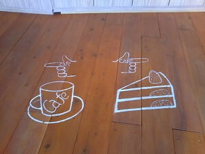 パティスリー・ルセットの正面床にカフェかテイクアウトケーキかの方向案内