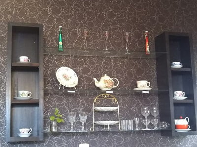 喫茶＆洋風居酒屋40(よんまる)の座った席から見える向かいの壁にカップ&ソーサーがお洒落に飾られている