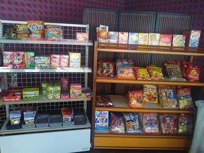 奥野製菓舗のショーケース隣には棚に普通のお菓子類が並ぶ