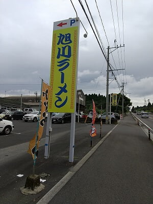 旭川ラーメンの立て看板は道路から黄色で目立つ