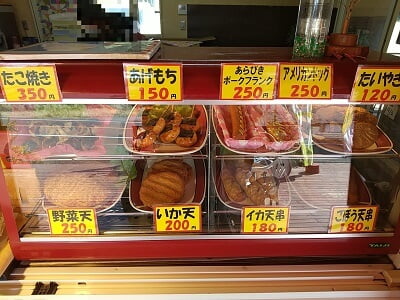 錦江湾せんべいの更に右はたこ焼き、あげもち、アメリカンドッグ、たいやき、野菜天、いか天等ショーケースに並ぶ