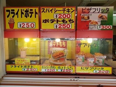 錦江湾せんべいの奧はポテト、チキン、ピザの実物が並ぶ