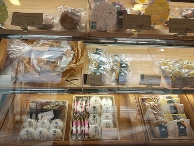 お菓子の松栄堂のショーケース左はギフト用の箱入りお菓子、ケーキやサブレに春駒が並ぶ