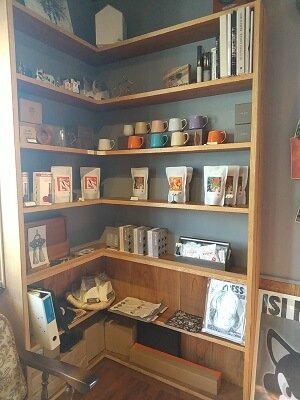 the Store.の右にはＬ字型の棚にコーヒー豆やカップが並ぶ