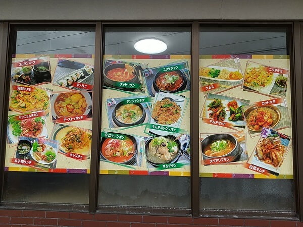 韓国家庭料理店ハナの窓ガラスにメニュー写真がたくさん貼ってある