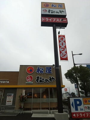 松のや 姶良加治木店(松屋併設)の道路沿いの立て看板に「オープン」の垂れ幕が下がってる