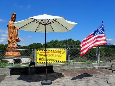 ALWAYS CAFE(オールウェイズ カフェ)の駐車場奥にパラソルとアメリカの国旗がある
