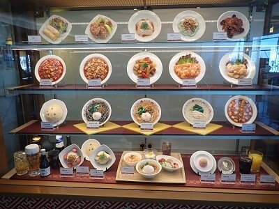 中國料理満正苑 鹿児島空港店の正面入り口横に食品サンプルのショーケース