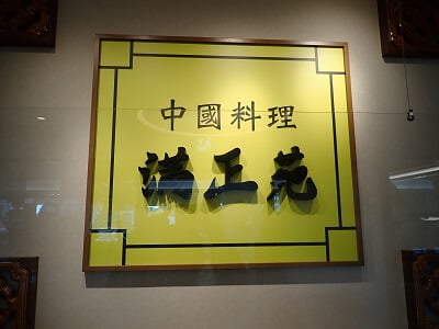 中國料理満正苑 鹿児島空港店の正面のレジ後ろの壁に立派な店名の看板