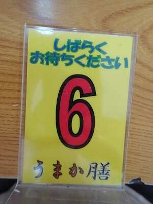 和牛門食堂の買った食券を厨房に出すと引き換えの番号札をもらった
