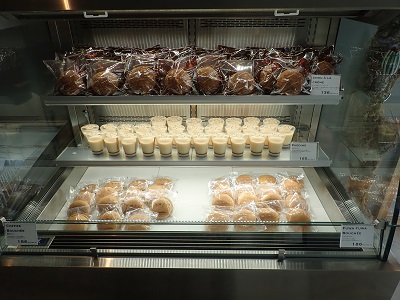 Andenken東開Holz店の左壁際の冷蔵コーナーにシュークリームやプリンが並ぶ