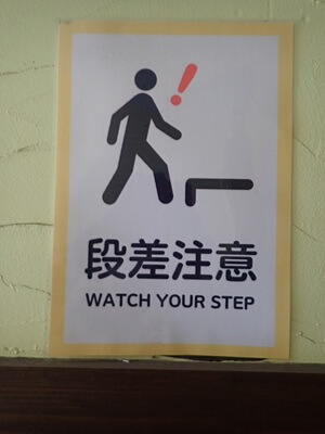 kitchen Gen (薔薇道)の入口ドア前の左壁に「段差注意」